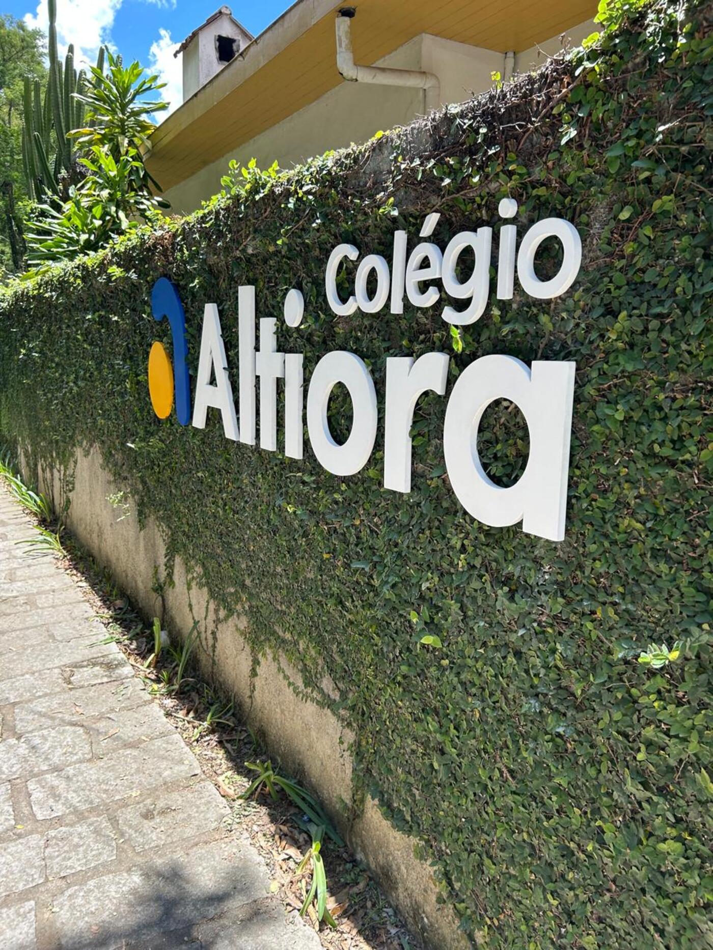 Fachada do Colégio Altiora com muro verde